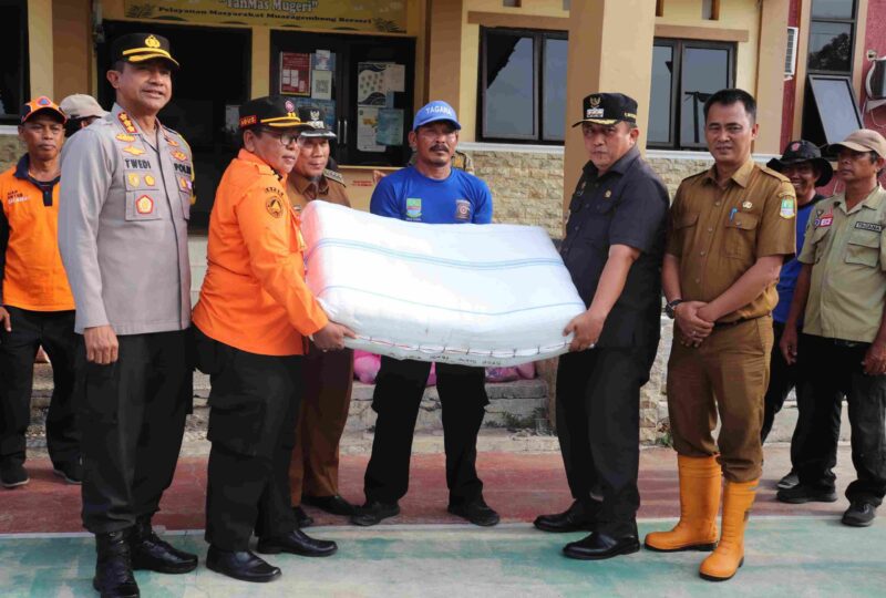 Pj Bupati Bekasi Dedy Supriyadi bersama Kapolres Metro Bekasi Kombes Pol Twedi Aditya Bennyahdi, menyerahkan bantuan untuk warga terdampak banjir rob di Kecamatan Muaragembong, pada Selasa (19/11/2024).