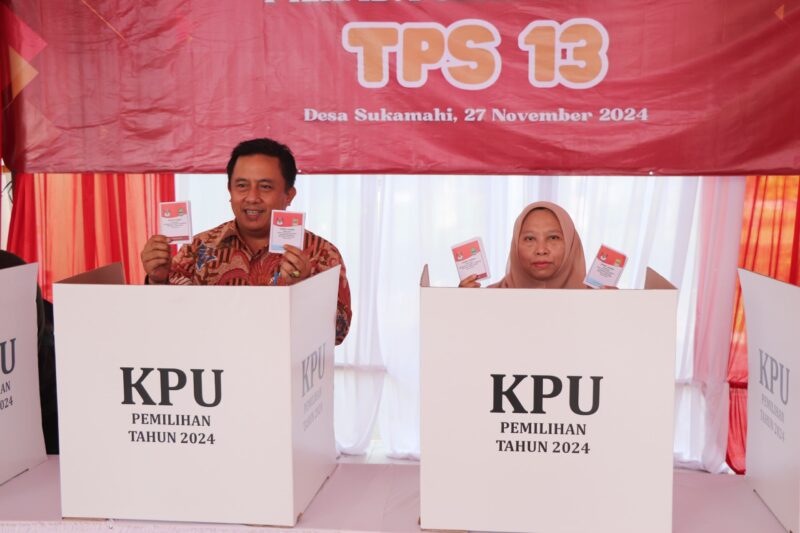 HAK SUARA : Pj Bupati Bekasi Dedy Supriyadi bersama Pj Ketua TP-PKK Kabupaten Bekasi, Wulur Hartanti menunaikan hak pilihnya pada Pilkada Serentak 2024 di TPS 13 Cluster Catania Kota Deltamas, Desa Sukamahi Kecamatan Cikarang Pusat, Rabu (27/11/2024).